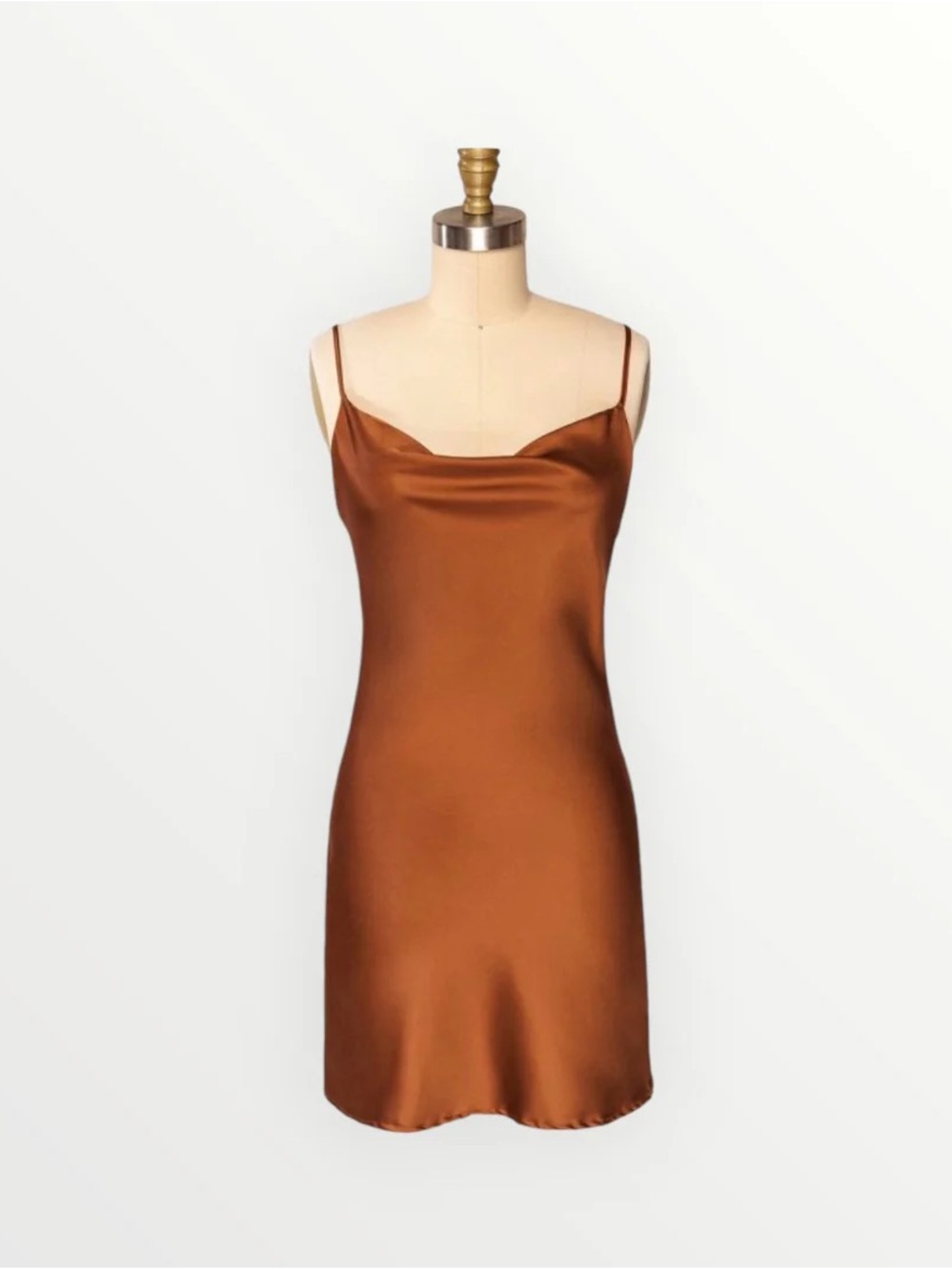 Rust-colored satin slip dress features a cowl neckline and spaghetti straps